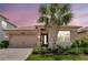 Charming single-story home with a two-car garage, landscaped front yard, and beautiful palm tree at 3060 Mountain Spruce Ter, Wesley Chapel, FL 33543