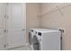 Well-lit laundry room features new front loading washer and dryer plus wire rack shelving at 3060 Mountain Spruce Ter, Wesley Chapel, FL 33543