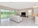 Bright living room featuring sliding glass doors to the backyard and neutral decor and tile floors at 3060 Mountain Spruce Ter, Wesley Chapel, FL 33543