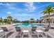 Resort-style community pool with ample lounge seating and swaying palm trees under a clear blue sky at 3060 Mountain Spruce Ter, Wesley Chapel, FL 33543