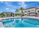 Beautiful community pool with a palm tree and cabanas, perfect for relaxation and socializing at 3060 Mountain Spruce Ter, Wesley Chapel, FL 33543