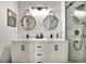Modern bathroom with double sinks, sleek black fixtures, contemporary mirrors, and a glass-enclosed shower at 310 S Willow Ave # A, Tampa, FL 33606