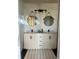 This bathroom features dual sinks, neutral cabinets, black hardware and round mirrors at 310 S Willow Ave # A, Tampa, FL 33606