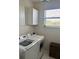 Bright laundry room with white cabinets, washer, and dryer near window at 310 S Willow Ave # A, Tampa, FL 33606