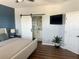 This main bedroom features barn door access to the bathroom, wood plank accent wall and wood floors at 310 S Willow Ave # A, Tampa, FL 33606