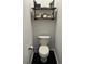 This powder room features black hardware, decorative shelves and black hexagonal tiled floors at 310 S Willow Ave # A, Tampa, FL 33606