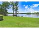Lush green lawn leads to a tranquil lake with a charming dock and gazebo at 3145 Lake Ellen Dr # 3145, Tampa, FL 33618