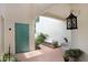 Charming courtyard with a teal door, brick pavers, a white bench, and lush plants at 3145 Lake Ellen Dr # 3145, Tampa, FL 33618