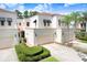 Exterior view of townhomes featuring manicured landscaping, garages, and black awnings at 3145 Lake Ellen Dr # 3145, Tampa, FL 33618