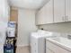 Functional laundry room equipped with a washer, dryer, sink, and storage cabinets at 3145 Lake Ellen Dr # 3145, Tampa, FL 33618