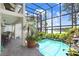 Enclosed pool area with lush greenery, a waterfall feature, and a seating area with a table and chairs at 3145 Lake Ellen Dr # 3145, Tampa, FL 33618