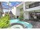 Spacious indoor pool with spa, waterfall feature, lush foliage, and access to an outdoor dining area and balcony at 3145 Lake Ellen Dr # 3145, Tampa, FL 33618