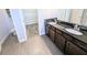 Bathroom featuring double sinks, granite counters, a glass shower, and access to walk-in closet at 32599 Natural Bridge Rd, Wesley Chapel, FL 33543