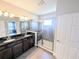 Bathroom featuring double sinks, granite counters, a glass shower, and access to another room at 32599 Natural Bridge Rd, Wesley Chapel, FL 33543