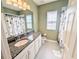 Well-lit bathroom with vanity, granite counters, mirror and shower with curtain at 32599 Natural Bridge Rd, Wesley Chapel, FL 33543