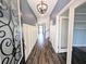 Stylish entryway with decorative front door, wood-look tile flooring, and white wainscoting on blue walls at 32599 Natural Bridge Rd, Wesley Chapel, FL 33543