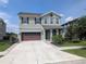 Inviting two-story home showcasing a spacious driveway, attached two-car garage, and well-maintained landscaping at 32599 Natural Bridge Rd, Wesley Chapel, FL 33543