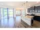 Spacious kitchen with granite island, stainless appliances, wood-look flooring, and open view to living area at 32599 Natural Bridge Rd, Wesley Chapel, FL 33543