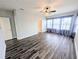 Spacious living room with plank flooring, large windows, and tasteful curtains creating a bright ambiance at 32599 Natural Bridge Rd, Wesley Chapel, FL 33543