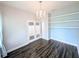 Bright office space with beautiful hardwood floors, a modern light fixture, and stylish built-in shelves at 32599 Natural Bridge Rd, Wesley Chapel, FL 33543