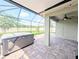 Relaxing screened-in patio with a hot tub and lovely stone pavers overlooking the manicured yard at 32599 Natural Bridge Rd, Wesley Chapel, FL 33543