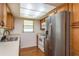 Kitchen features wooden cabinets, stainless-steel refrigerator, white range, and plenty of natural light at 3547 Morley Dr, New Port Richey, FL 34652
