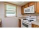 Bright kitchen features white appliances, wooden cabinets, and lots of natural light at 3547 Morley Dr, New Port Richey, FL 34652