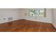 The living room features hardwood floors and a large window, providing natural light and a view of the front yard at 3547 Morley Dr, New Port Richey, FL 34652