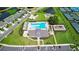 Aerial view of a community pool, playground, tennis courts, and surrounding houses and landscaping at 36618 Garden Wall Way, Zephyrhills, FL 33541