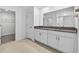 Bathroom featuring double vanity, granite countertop, tile floor, and walk-in closet access at 36618 Garden Wall Way, Zephyrhills, FL 33541