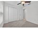 Bedroom with carpet, ceiling fan, closet, and door to bathroom at 36618 Garden Wall Way, Zephyrhills, FL 33541