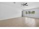 Spacious bedroom with tile floors, a ceiling fan, and a large window providing natural light at 36618 Garden Wall Way, Zephyrhills, FL 33541