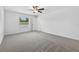 Bedroom showcasing a large window, carpeted floor and ceiling fan at 36618 Garden Wall Way, Zephyrhills, FL 33541