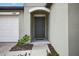Close up of the front door with visible house number, door hardware, and landscaping at 36618 Garden Wall Way, Zephyrhills, FL 33541