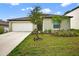 Charming single-story home featuring a two-car garage and a well-manicured lawn with young trees at 36618 Garden Wall Way, Zephyrhills, FL 33541
