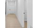 Clean hallway with tile floors, white walls, and doors leading to other rooms in the house at 36618 Garden Wall Way, Zephyrhills, FL 33541