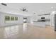 Bright open floor plan with tile flooring, ceiling fan, and sliding glass door to the backyard at 36618 Garden Wall Way, Zephyrhills, FL 33541