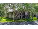 Well-maintained two-story condo building with lush landscaping and mature trees at 4012 Tumble Wood Trl # 104, Tampa, FL 33613