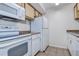 Kitchen features white appliances, wood cabinets, light countertop and tile flooring at 4012 Tumble Wood Trl # 104, Tampa, FL 33613