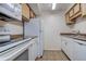 Kitchen features white appliances, wood cabinets, light countertop and tile flooring at 4012 Tumble Wood Trl # 104, Tampa, FL 33613