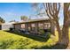 Landscaped backyard with healthy green lawn, garden beds, and mature shade tree at 4085 105Th N Ave, Clearwater, FL 33762