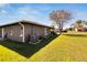 Landscaped backyard with healthy green lawn, garden beds, and mature shade tree at 4085 105Th N Ave, Clearwater, FL 33762