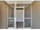 View of the house's front door through the screened entryway, and a small wicker bench at 4085 105Th N Ave, Clearwater, FL 33762