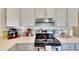 Kitchen featuring stainless steel appliances and white cabinetry at 4085 105Th N Ave, Clearwater, FL 33762