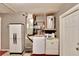 Functional laundry room with washer, dryer, utility sink, shelving, and closet for storage at 4085 105Th N Ave, Clearwater, FL 33762