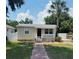 Charming single-story home featuring a cozy front porch, well-kept lawn, and attractive landscaping at 4111 W Grace St, Tampa, FL 33607