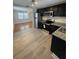 Well-lit kitchen featuring stainless steel appliances, granite counters, dark cabinets, and wood-look floors at 4111 W Grace St, Tampa, FL 33607