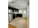 Modern kitchen with stainless steel appliances, dark cabinetry, granite countertops, and new flooring at 4111 W Grace St, Tampa, FL 33607