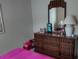 Bedroom with a dark wood dresser with mirror and a pink comforter on the bed at 432 Flamingo Dr, Apollo Beach, FL 33572