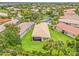 An aerial view of a home's large lot with mature landscaping, lush green grass, and an enclosed lanai at 4911 Rock Island Ct, Wimauma, FL 33598